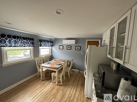 A kitchen with a table and chairs in front of a window.