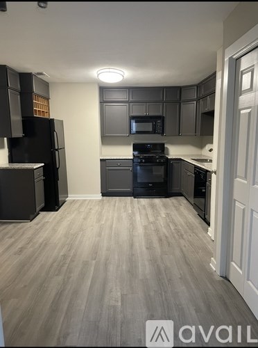 A kitchen with a black refrigerator and stove.