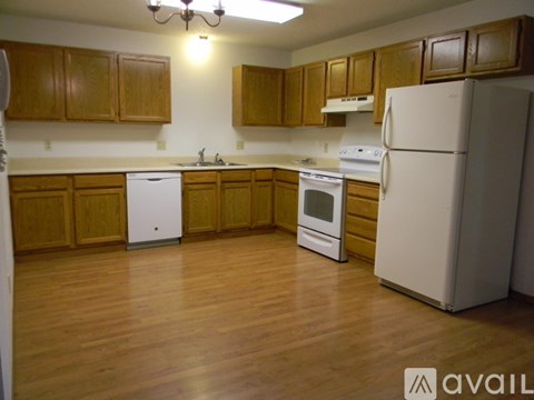 A kitchen with wooden cabinets and white appliances.