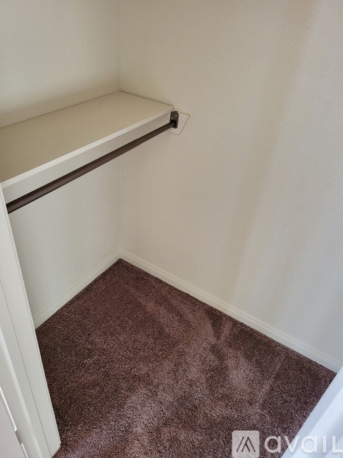A corner of a room with a brown carpet.