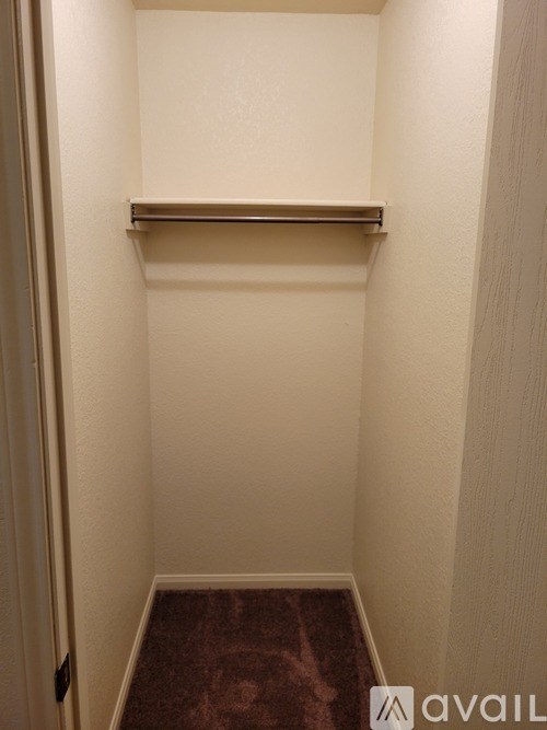 A small, empty room with a shelf and a door.