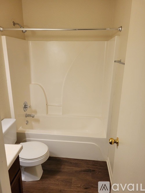 A white toilet sits next to a white bathtub in a small bathroom.