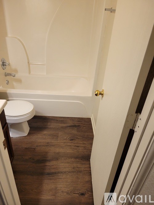 A white toilet sits next to a bathtub in a bathroom.
