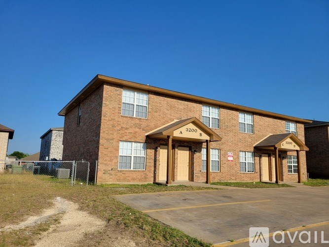 A brick building with the number 3200 on the front door.