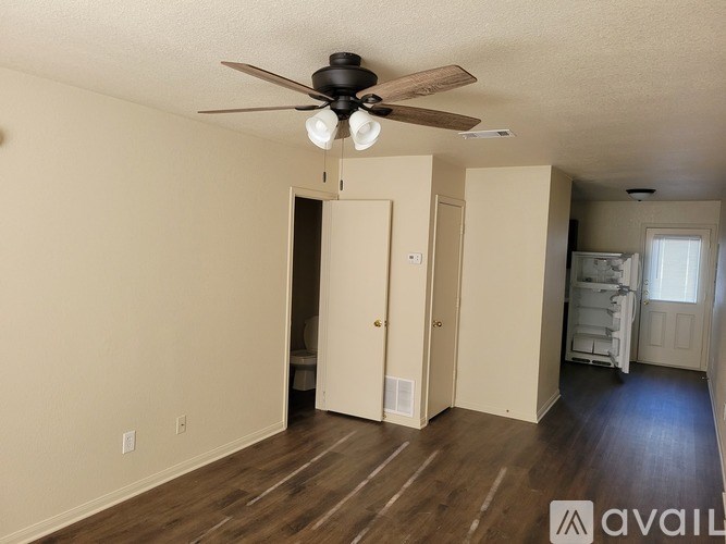A room with a ceiling fan and wooden floors.