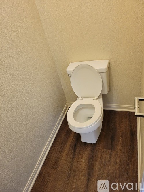 A white toilet with the seat up in a small bathroom.
