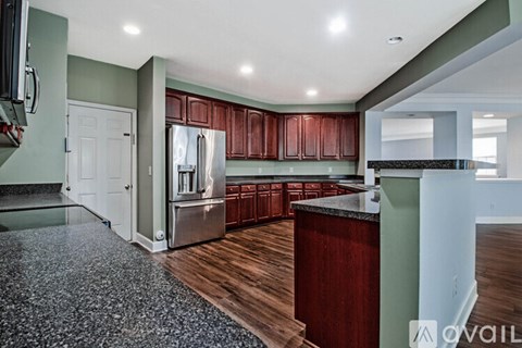 A kitchen with wood cabinets and a granite counter top.