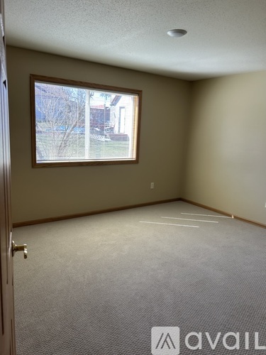 A room with a window and a door is available for rent.