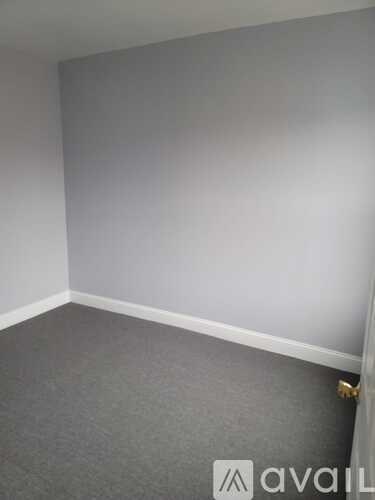 A room with grey carpet and white walls.