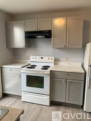 A kitchen with white appliances and cabinets.