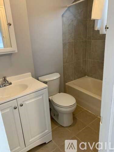 A bathroom with a toilet, sink, and bathtub.