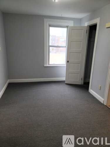 A room with a carpeted floor and a window.