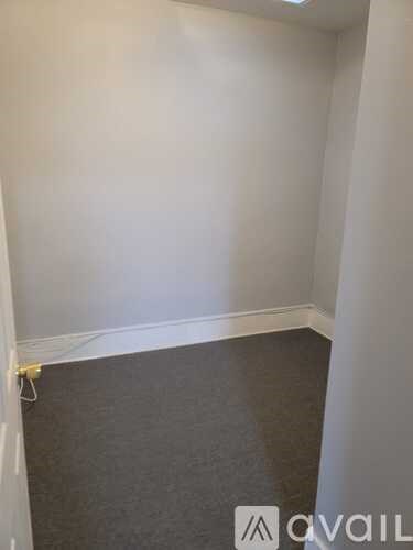 A room with grey carpet and white walls.