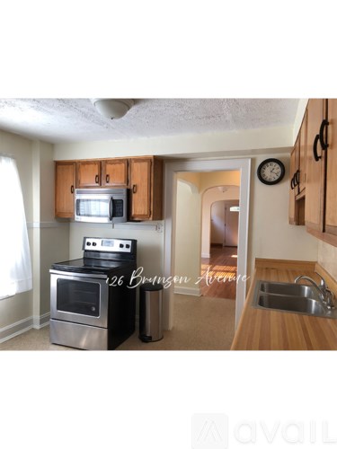 A kitchen with wooden cabinets and a stainless steel oven.