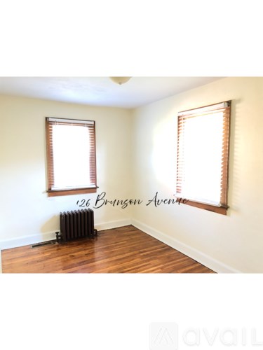 A room with a window and a radiator on the floor.