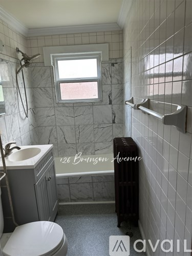 A bathroom with a toilet, sink, and a window.