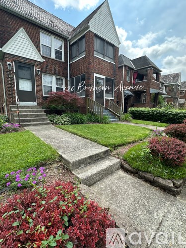 A brick house with a sign that says "Broadway Avenue" in front of it.