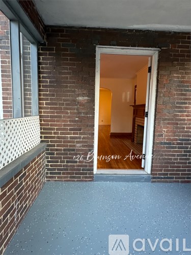 A brick wall with a doorway leading to a room.