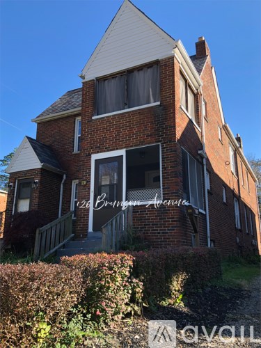 A red brick house with a sign that says "20 Bring Avenue".