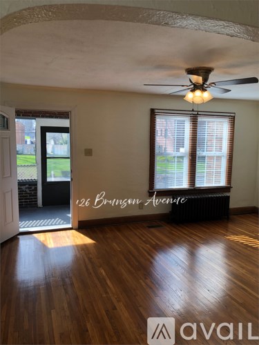 A room with a ceiling fan and a window with blinds.