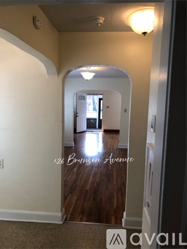A hallway with a carpeted floor and a light on the ceiling.