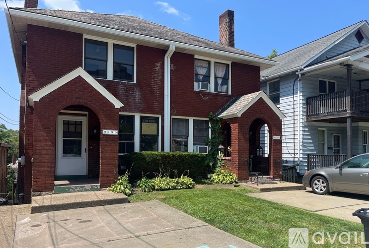 A red brick house with a white door and windows.