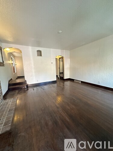 A room with wooden floors and two doors.