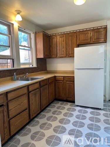 A kitchen with wooden cabinets and a white fridge.