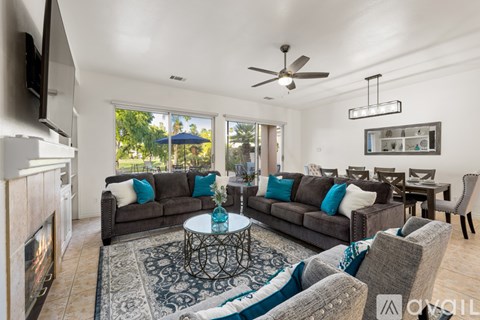 A living room with a grey couch and a fireplace.