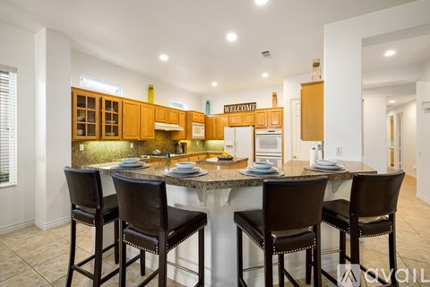 A kitchen with a table and chairs in front of it.