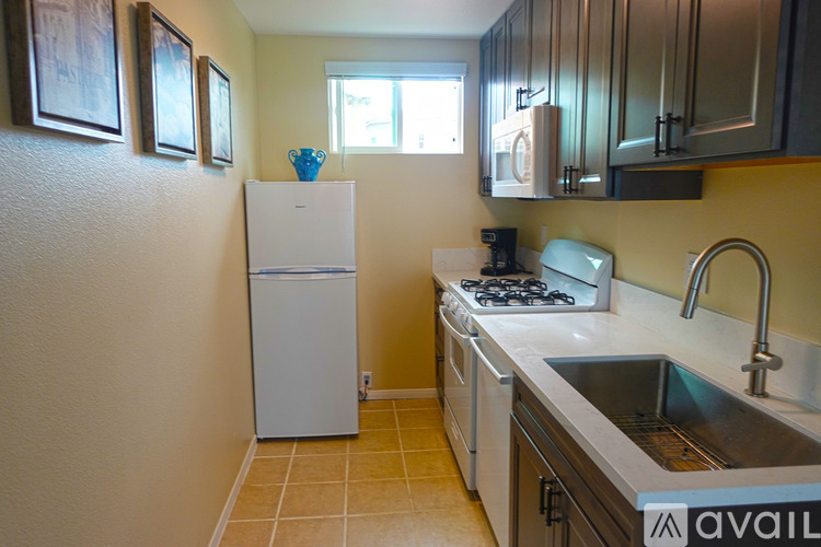 A kitchen with a white refrigerator and stove top oven.
