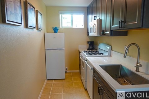 A kitchen with a white refrigerator and stove top oven.