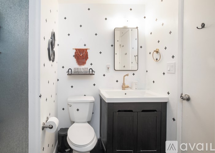 A bathroom with a toilet, sink, and mirror.