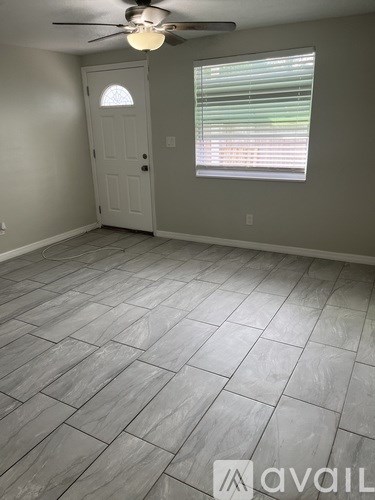 A room with a ceiling fan and a door.