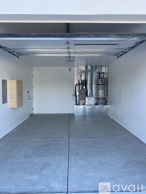 A large empty room with a concrete floor and white walls.