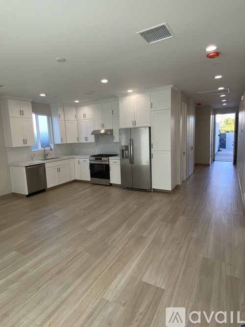 A spacious kitchen with white cabinets and stainless steel appliances.