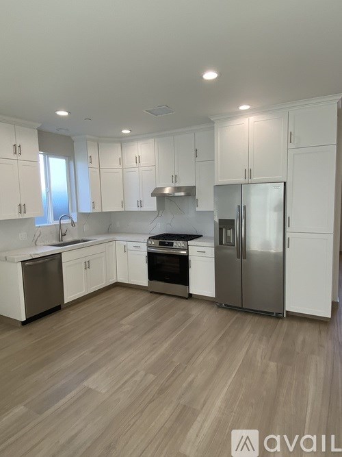 A kitchen with white cabinets and stainless steel appliances.