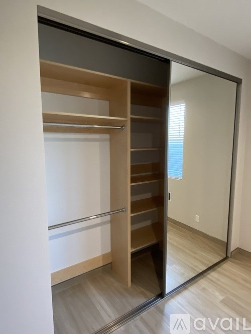 A modern closet with a sliding door and shelves.
