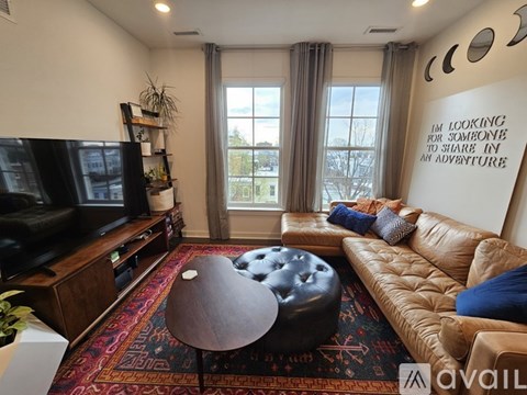 A living room with a brown leather couch and a wooden coffee table.