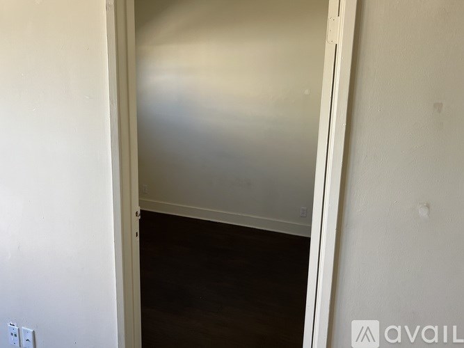 A room with a white wall and a wooden floor.