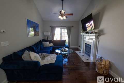 A living room with a blue couch and a fireplace.