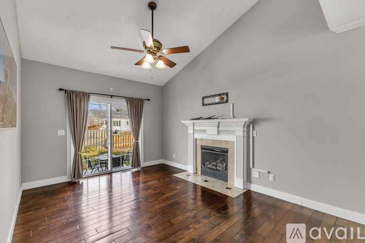 A living room with a blue couch and a painting of a desert scene on the wall.
