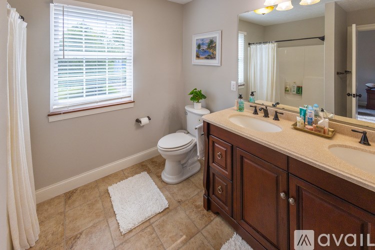 A bedroom with a bed, nightstand, and window.
