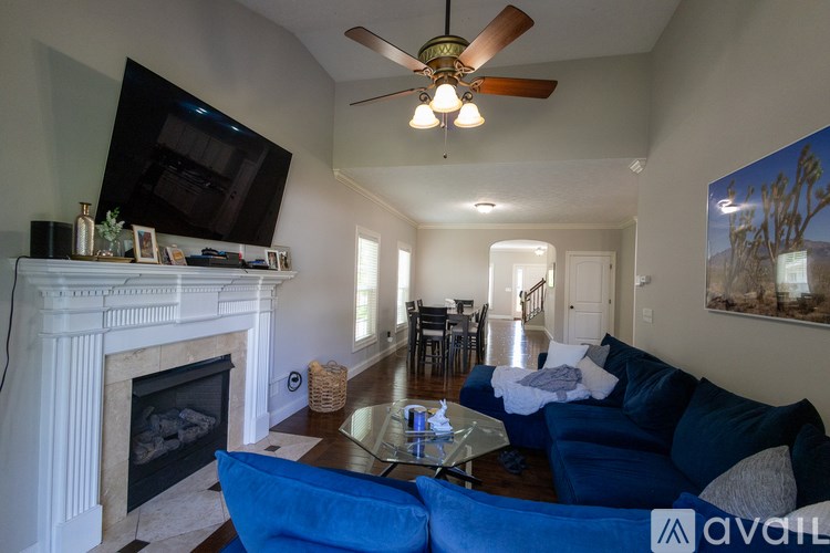 A living room with a fireplace and a television mounted above it.