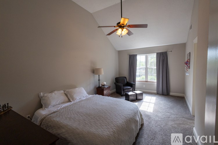 A bedroom with a large bed and a ceiling fan.
