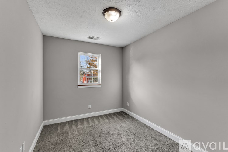 A room with a desk, chair, and a painting on the wall.
