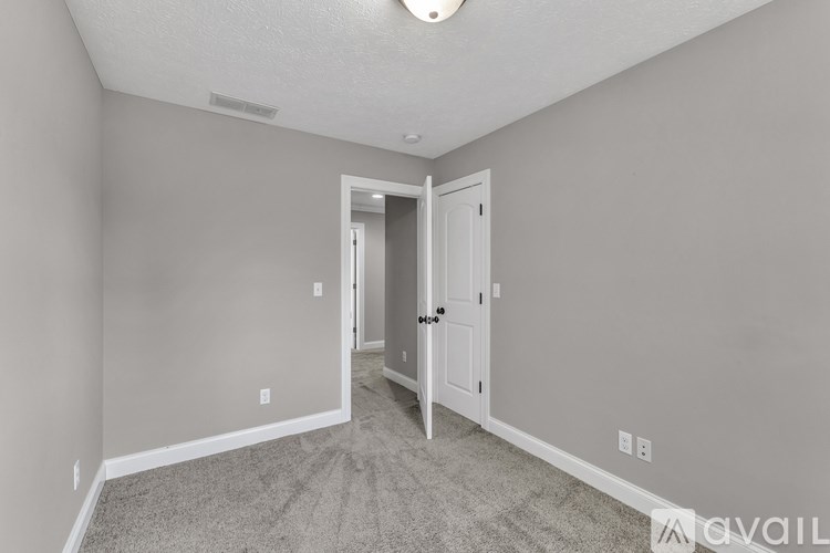 A room with a desk, chairs, and a bookshelf.
