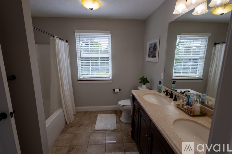 A bathroom with a toilet, sink, and shower.