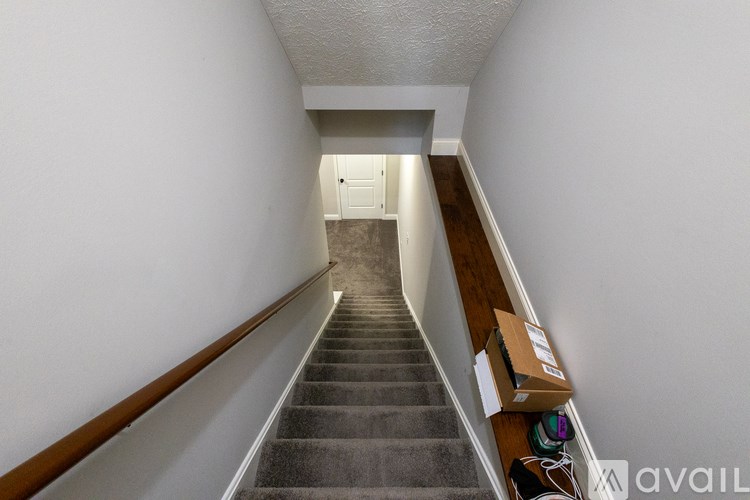 A long hallway with a staircase leading to a door at the end.