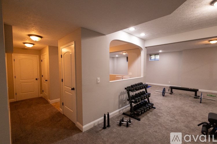 A room with a gym setup including weights and a bench.